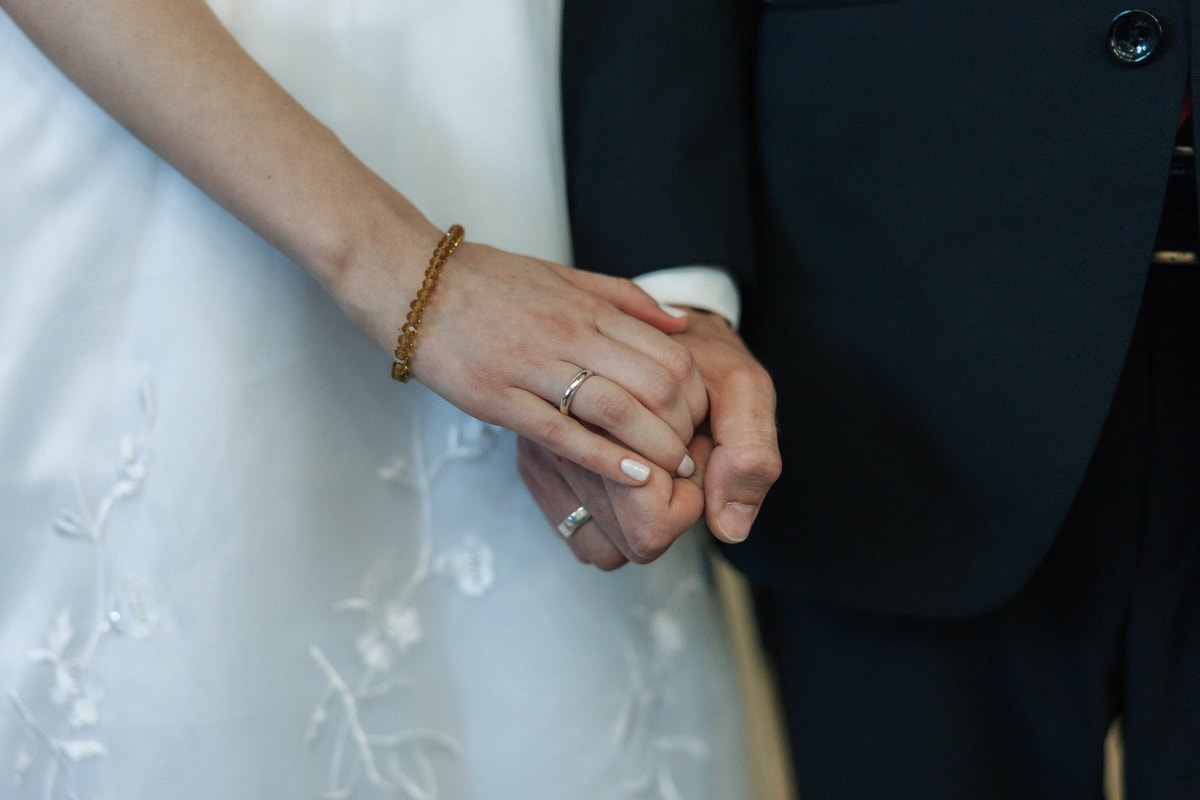 The couple's hands showing their wedding rings