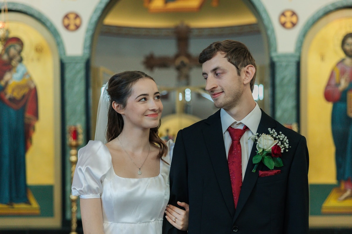 The bride and groom stand together for portraits inside the church