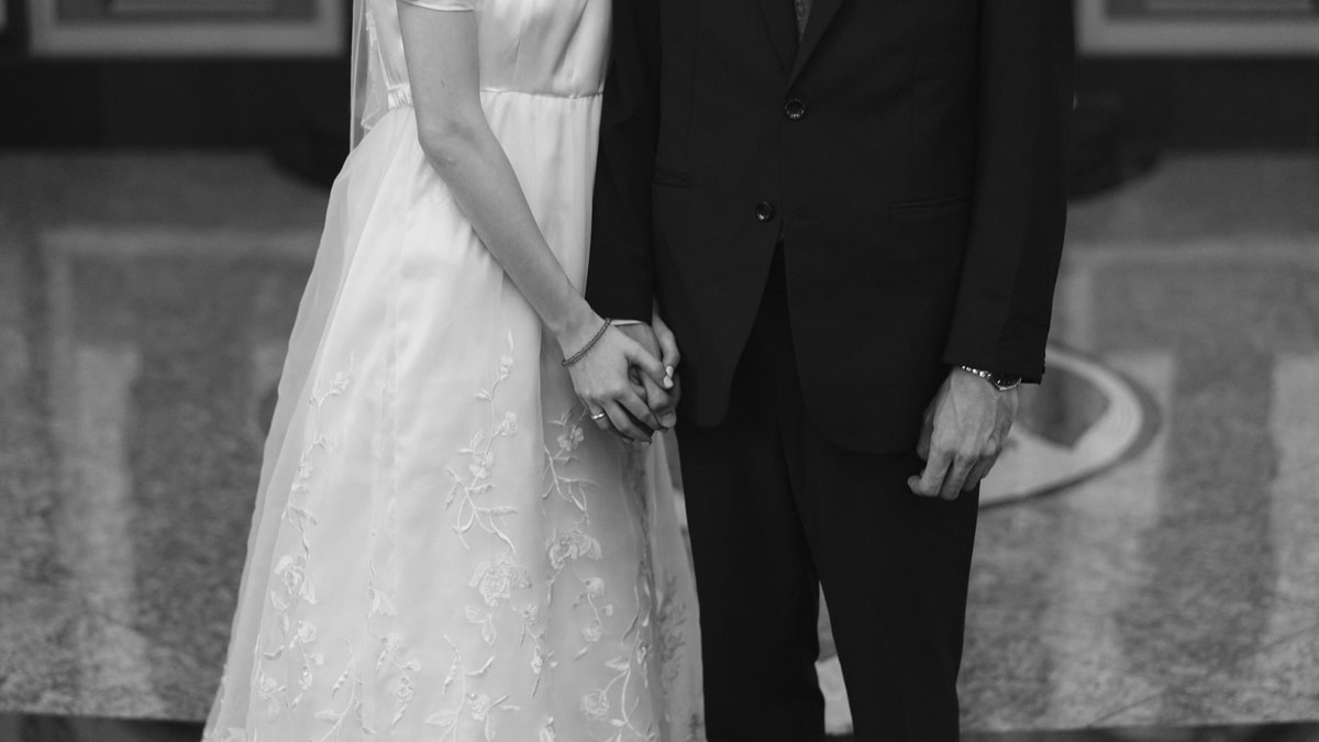 The couple's hands in a black-and-white wedding portrait