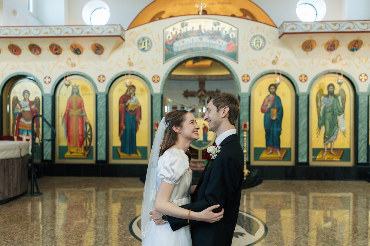 The bride and groom kiss inside the church