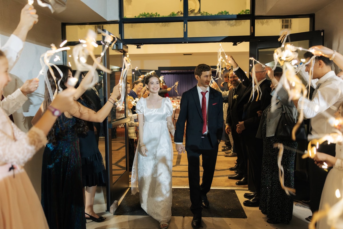 The bride and groom walk through a sparkler exit