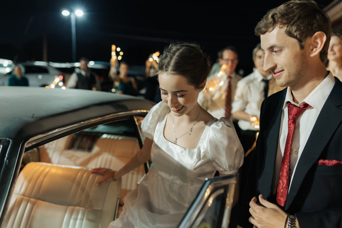 The bride and groom step into their getaway car